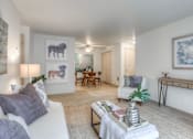 Thumbnail 6 of 14 - A living room with a white couch, a coffee table, and a painting of a bear on the wall.