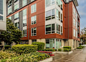 Thumbnail 4 of 25 - A modern building with a combination of red and grey exterior.