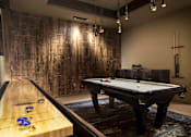 Thumbnail 13 of 21 - A pool table with a lighted billiard table in the background.