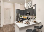 Thumbnail 2 of 24 - a kitchen with a large island and a stainless steel refrigerator