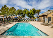 Thumbnail 10 of 20 - A large swimming pool with a blue tinted water surrounded by a fence and chairs.