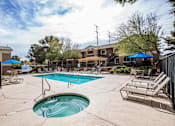 Thumbnail 9 of 20 - A swimming pool with a slide and lounge chairs.