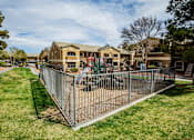 Thumbnail 15 of 20 - A playground area is enclosed by a fence in a grassy yard.