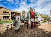 Thumbnail 16 of 20 - A playground with a slide, swings, and a seesaw.