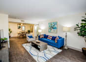 Thumbnail 1 of 20 - A living room with a blue couch and a television.