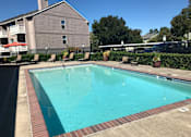 Thumbnail 14 of 16 - A swimming pool surrounded by a brick border and lounge chairs.