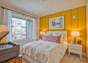 Thumbnail 9 of 37 - a bedroom with an orange accent wall and a bed