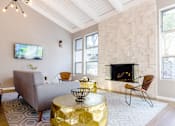 Thumbnail 23 of 27 - a living room with a fireplace and a couch and a table