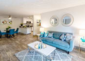 Thumbnail 2 of 27 - a living room with a blue couch and a coffee table