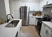 Thumbnail 32 of 32 - A kitchen with a stainless steel refrigerator and black oven.