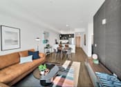 Thumbnail 3 of 30 - a living room with a brown couch and a table