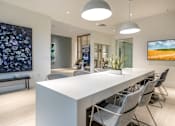 Thumbnail 11 of 25 - A modern conference room with a long white table and grey chairs.