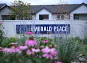 Thumbnail 26 of 32 - a sign for emerald place in front of a building with flowers