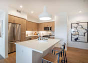 Thumbnail 1 of 38 - a kitchen with a large island and a stainless steel refrigerator