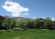 Thumbnail 18 of 29 - a group of houses with trees and mountains in the background