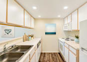 Thumbnail 13 of 29 - a kitchen with white appliances and wooden cabinets and a sink
