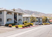 Thumbnail 3 of 29 - a row of apartment buildings with mountains in the background