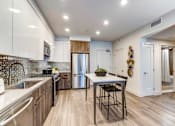Thumbnail 2 of 23 - a kitchen with stainless steel appliances and a table with two stools