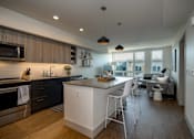 Thumbnail 1 of 26 - a kitchen and living room with an island and stools