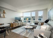 Thumbnail 6 of 26 - a living room with couches and tables and a large window