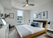 Thumbnail 3 of 26 - a bedroom with a large bed and a ceiling fan