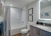 Thumbnail 5 of 26 - a bathroom with a shower toilet and sink and a mirror