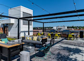 Thumbnail 21 of 26 - a rooftop patio with tables and chairs and a canopy