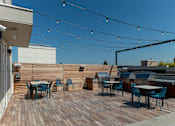 Thumbnail 23 of 26 - a roof deck with tables and chairs and a barbecue grill