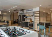Thumbnail 12 of 26 - a game room with a foosball table and a kitchen