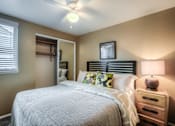 Thumbnail 8 of 16 - A bedroom with a bed, nightstand, and a ceiling fan.