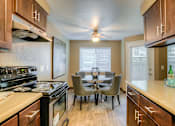 Thumbnail 9 of 16 - A kitchen with a dining table and chairs.