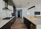 Thumbnail 3 of 26 - a large kitchen with marble counter tops and wooden floors