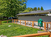 Thumbnail 24 of 27 - A green mailbox sits on a wooden fence in front of a house.