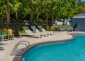Thumbnail 21 of 27 - A pool surrounded by trees and chairs.