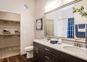 Thumbnail 11 of 24 - A bathroom with a toilet, sink, and mirror.