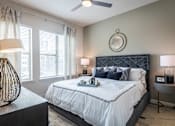 Thumbnail 3 of 24 - A bedroom with a large bed and a ceiling fan.