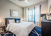 Thumbnail 7 of 24 - A bedroom with a large bed and a ceiling fan.