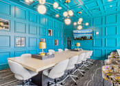Thumbnail 36 of 41 - a conference room with blue walls and a long table with chairs