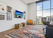 Thumbnail 39 of 41 - a living room with a couch and a rug and large windows