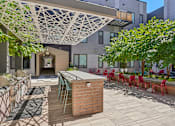 Thumbnail 24 of 41 - a patio with a bar and chairs and a building