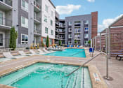 Thumbnail 13 of 34 - a swimming pool with an apartment building in the background
