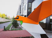 Thumbnail 22 of 23 - an orange and white sculpture in front of a building