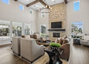 Thumbnail 15 of 30 - A modern living room with a stone fireplace and a large window.