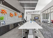 Thumbnail 14 of 24 - A modern kitchen with a dining table and chairs.
