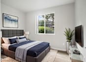 Thumbnail 6 of 23 - A bedroom with a bed, a nightstand, a lamp, a plant, a television, and a painting on the wall.