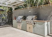 Thumbnail 23 of 30 - A row of outdoor grills are lined up on a patio.