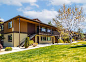 Thumbnail 28 of 29 - A modern house with a brown and beige exterior and a large front yard.