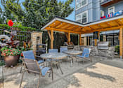 Thumbnail 12 of 32 - a patio with tables and chairs and a grill