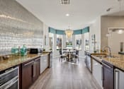 Thumbnail 31 of 33 - a kitchen with granite counter tops and a dining room with a table