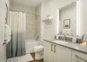 Thumbnail 4 of 24 - a bathroom with a shower toilet and sink and a mirror